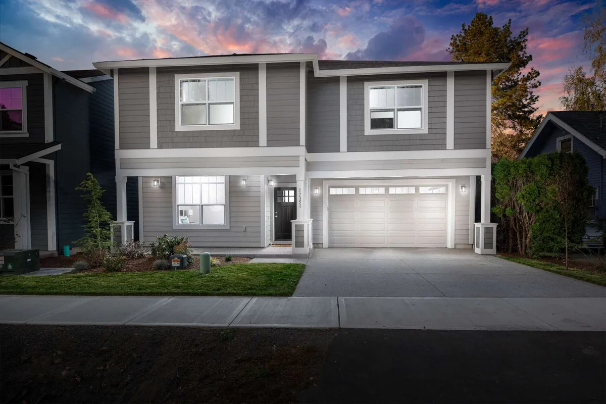 A modern exterior shot of the villa featuring a well-maintained front yard, symmetrical facade, and a large garage door. The space hints at outdoor gatherings, evening strolls, and seasonal activities, inviting families to make memories together.